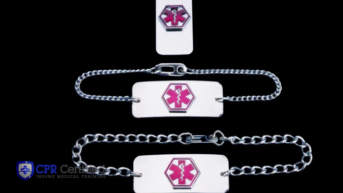 Three medical ID bracelets and a tag, each stamped with a pink star-of-life symbol.